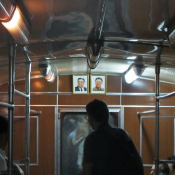 The inside of a Pyongyang metro carriage, with the ever-present portraits of Kim Il Sung and Kim Jong-il Pyongyang metro portraits